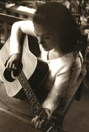 Black-and-white photograph of Wendy Curl playing acoustic guitar